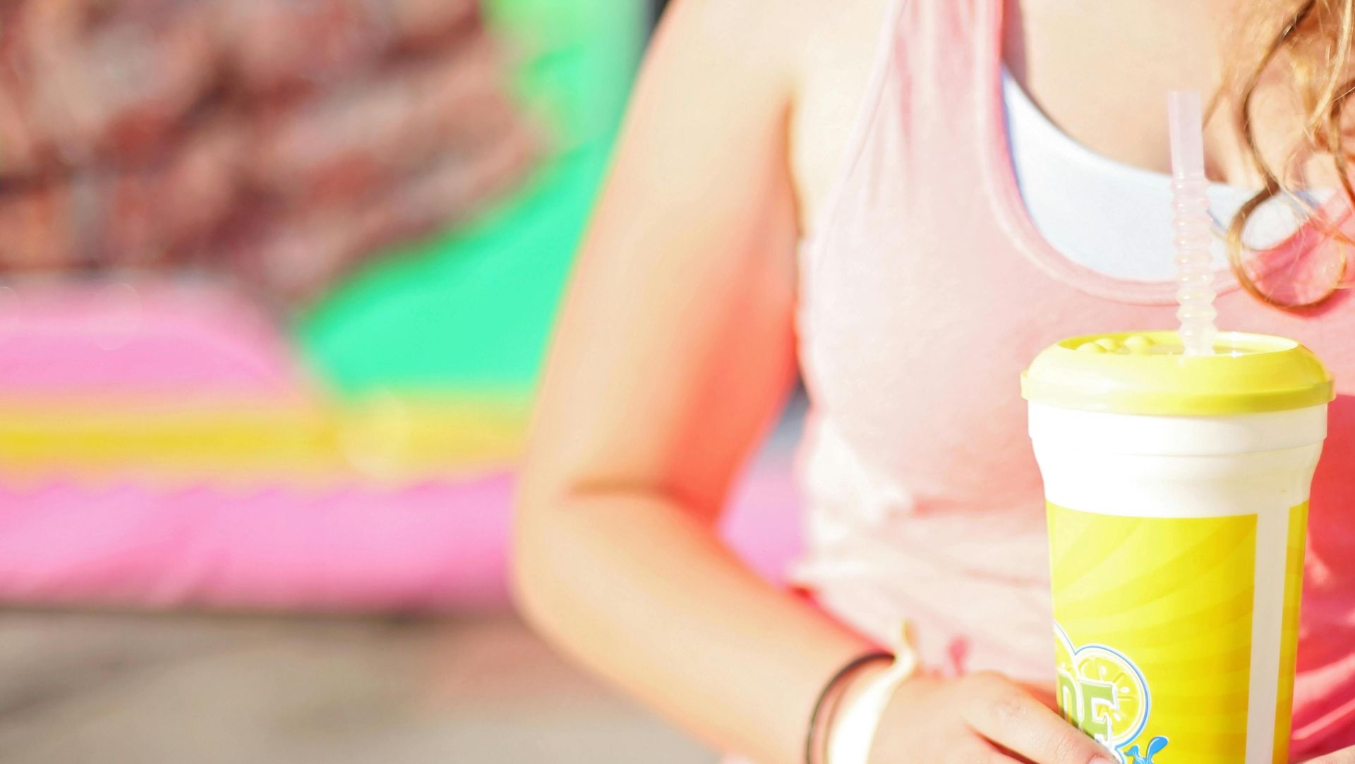 Close-up of a young woman holding a lemonade outdoors during summer.