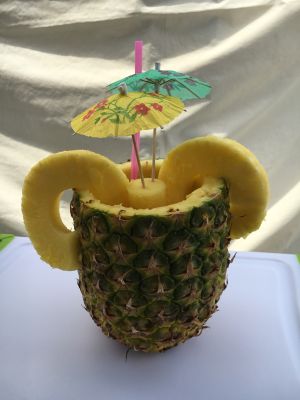 Hands adding syrup to shaved ice desserts creating vibrant treats.